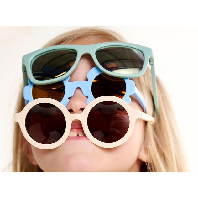 Babiators Navigator polarized kids sunglasses in sea-foam and blue tones; three pairs stacked on a child.
