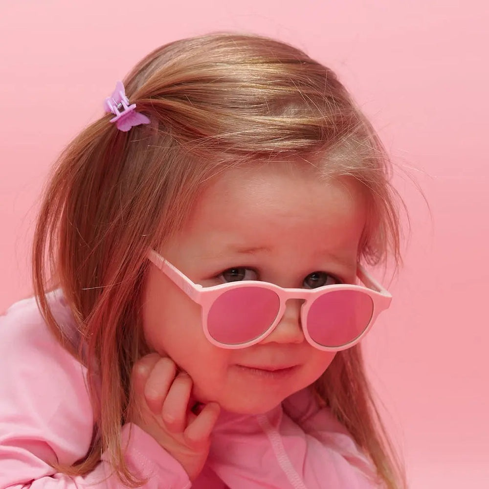Babiators Polarized Mirrored Sunglasses Keyhole Pretty In Pink worn by a girl, showing pink frames and mirrored lenses.