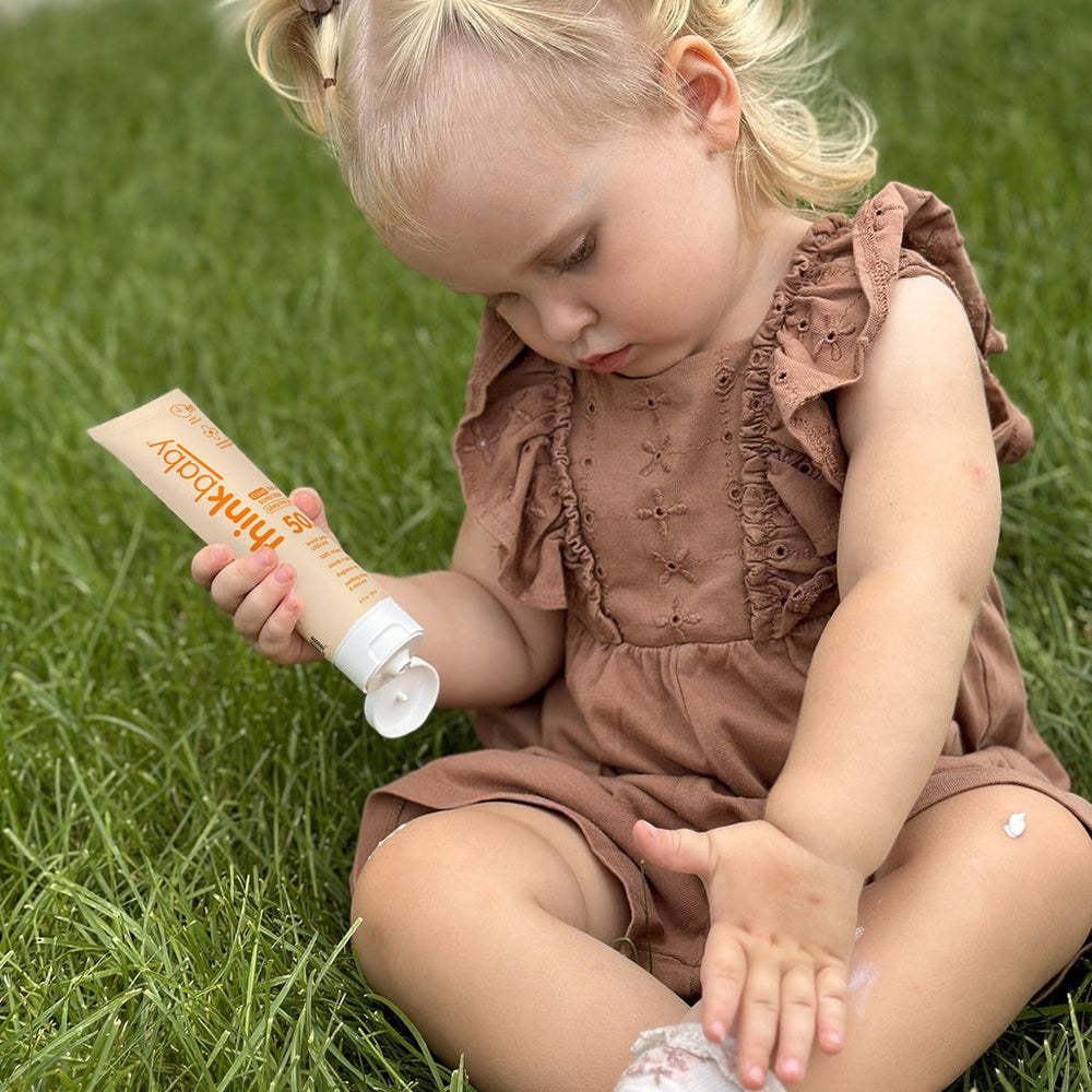 THINK Think Baby SPF 50+ Baby Clear Zinc Sunscreen for Sensitive Skin 3oz flip-top cap with white cream formula being applied img 2/5