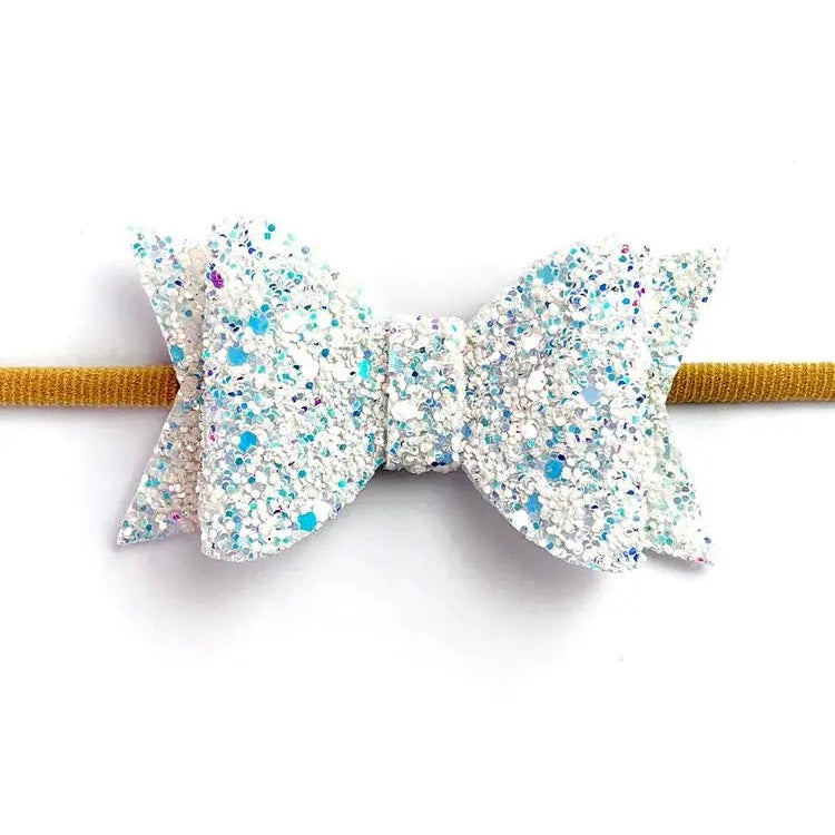 Baby Wisp Courtney Bow Headband in glitter silver with blue speckles on a mustard band.