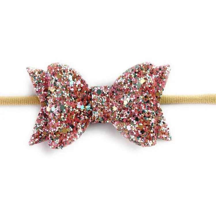 Baby Wisp Courtney Bow Headband featuring a pink glitter bow attached to a beige band.