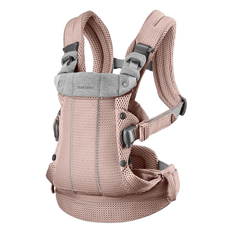 BabyBjorn Baby Carrier Harmony in blush pink, breathable mesh, worn with padded shoulder straps and waist belt.