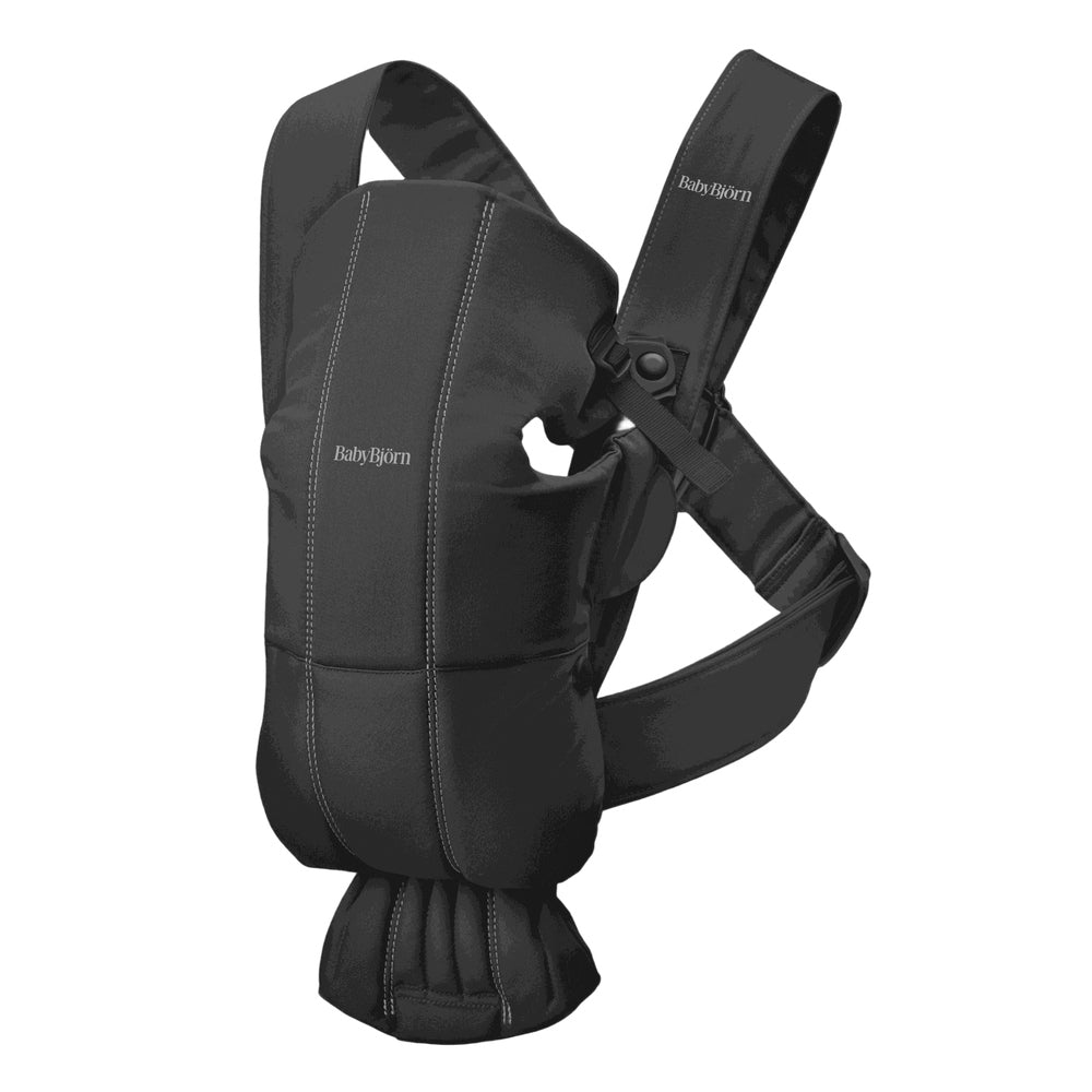 BabyBjorn Baby Carrier Mini in black being worn by a parent with padded shoulder straps and waist belt.