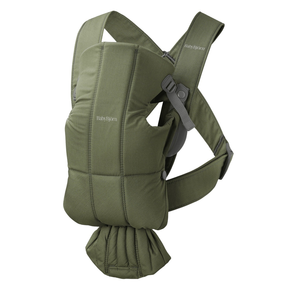BabyBjorn Baby Carrier Mini worn by a parent, olive-green soft-structured carrier with padded straps and waist belt.