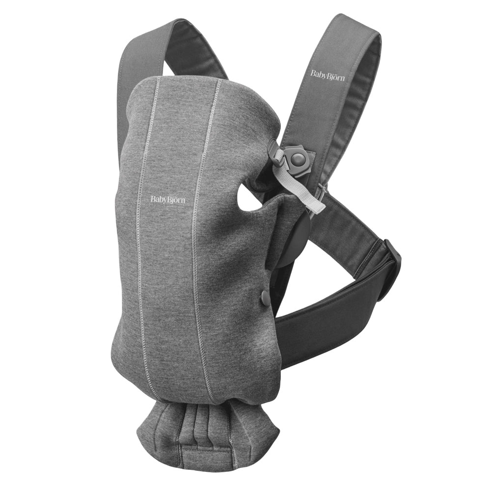 BabyBjorn Baby Carrier Mini in gray with padded shoulder straps and waist belt, ready to wear.