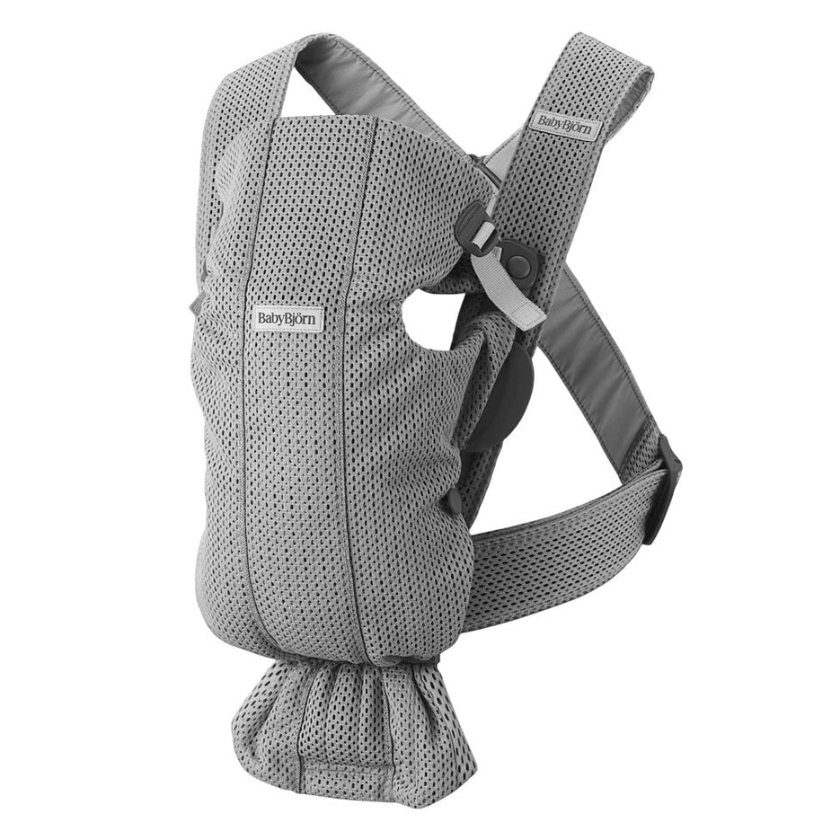BabyBjorn Baby Carrier Mini in gray mesh, shown worn on a parent with adjustable shoulder straps and waist belt.