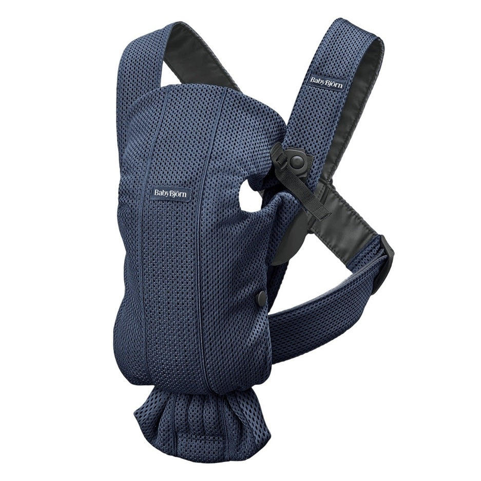 BabyBjorn Baby Carrier Mini in navy mesh with padded shoulders and waist belt, shown ready to wear.