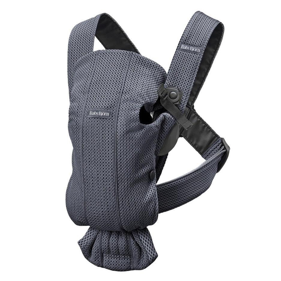 BabyBjorn Baby Carrier Mini in blue mesh worn by caregiver, with padded shoulder straps and secure waist belt.