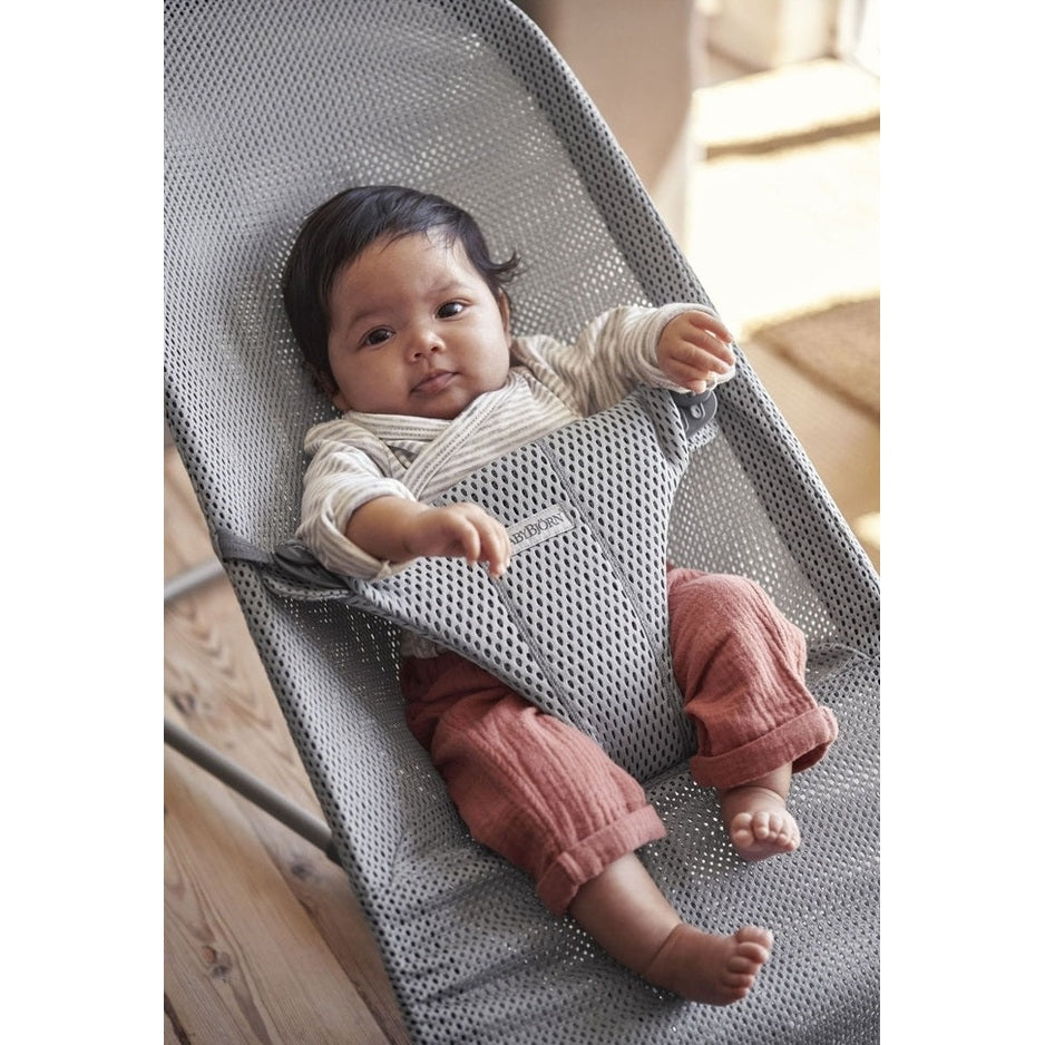 BabyBjorn Bouncer Bliss in grey mesh; baby sits securely in the supportive harness while lounging.