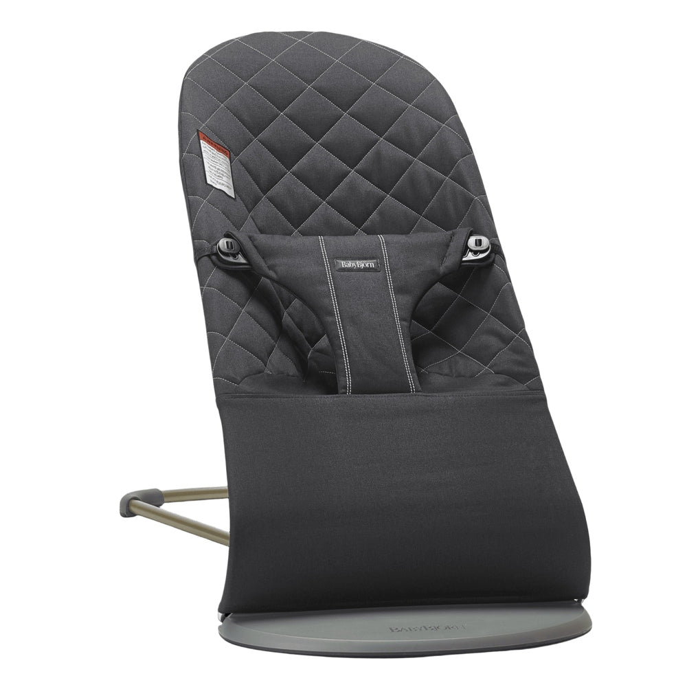 BabyBjorn Bouncer Bliss in dark gray quilted fabric with adjustable harness strapped across the front.