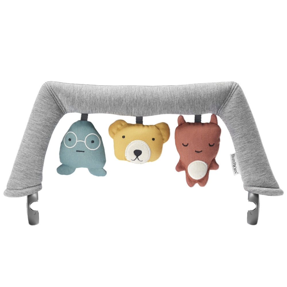 BabyBjorn Bouncer Toy with gray arched frame and three hanging plush characters in aqua, yellow, and rust.