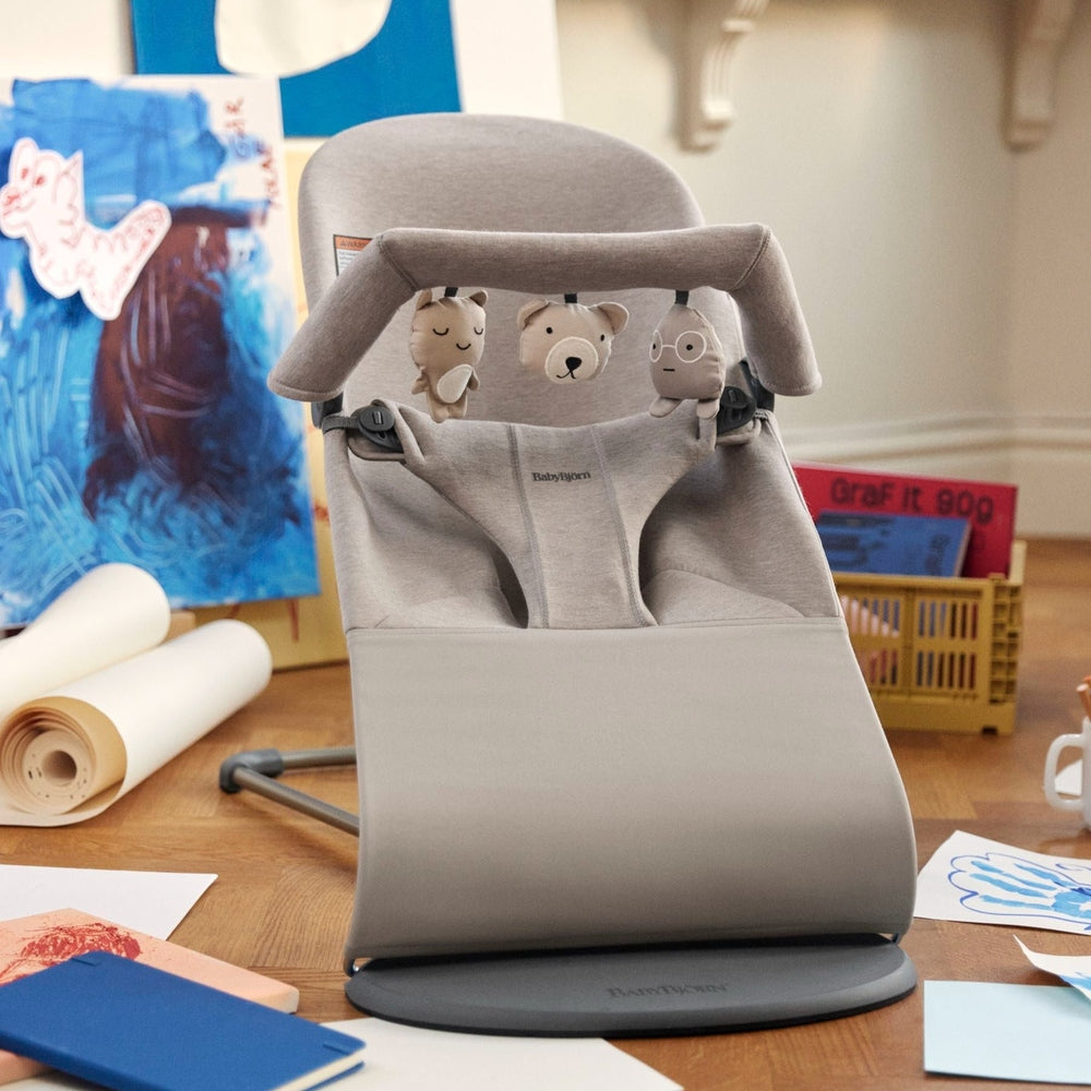 BabyBjorn Bouncer Toy in gray with plush animals hanging from a toy arch, ready for infant play.
