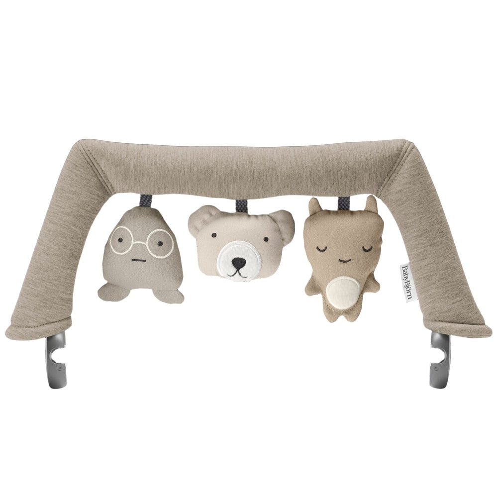 BabyBjorn Bouncer Toy arch in beige fabric with three hanging plush animals, inviting baby play.