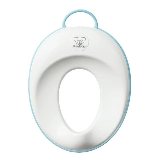 BabyBjorn Toilet Trainer in white with a light blue rim, built-in handle, and BABY BJORN logo.