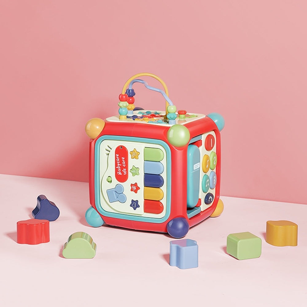 BC BABYCARE LEARNING ACTIVITY BOX, bright red toy with colorful panels, beads sliding on arches and piano keys.