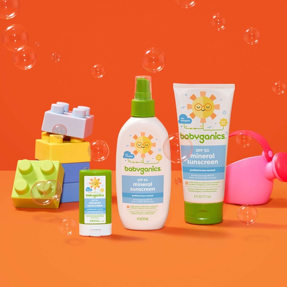 Babyganics mineral sunscreen SPF50 spray 6 oz with green cap; tube and stick sunscreen beside