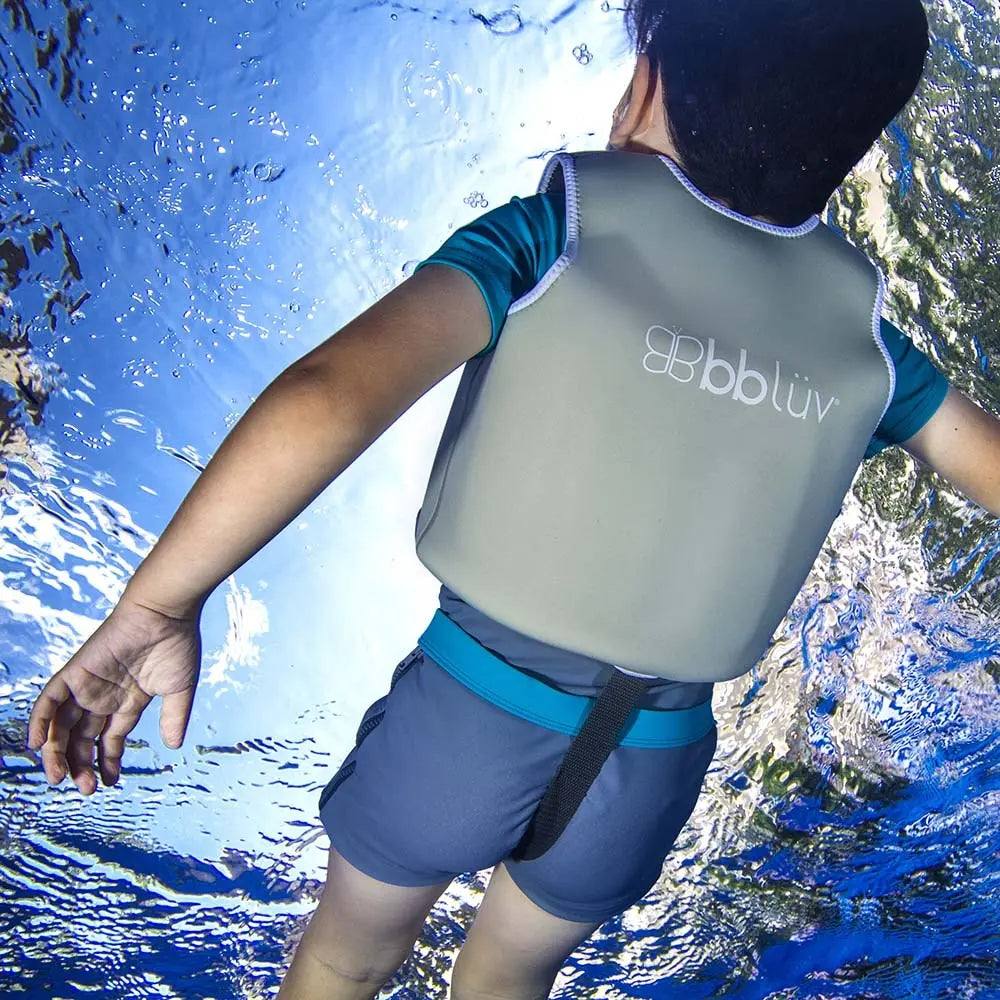 Bbluv Naj Evolutive Neoprene Swim Vest Aqua, child in aqua vest with adjustable waist belt, drifting in water.