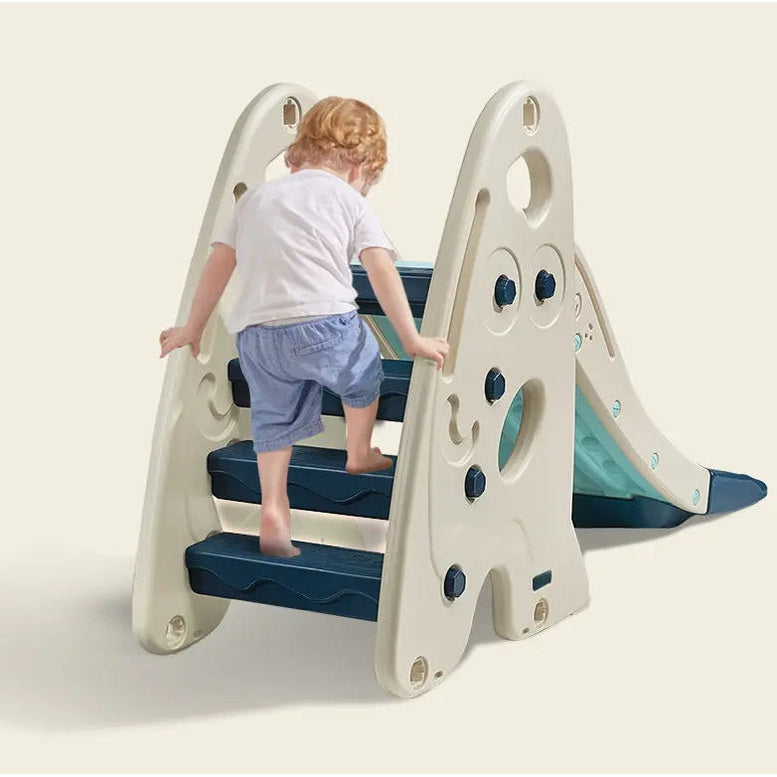 BC Babycare 5 In 1 Slide beige playset with navy steps; toddler climbs the stairs toward the slide.