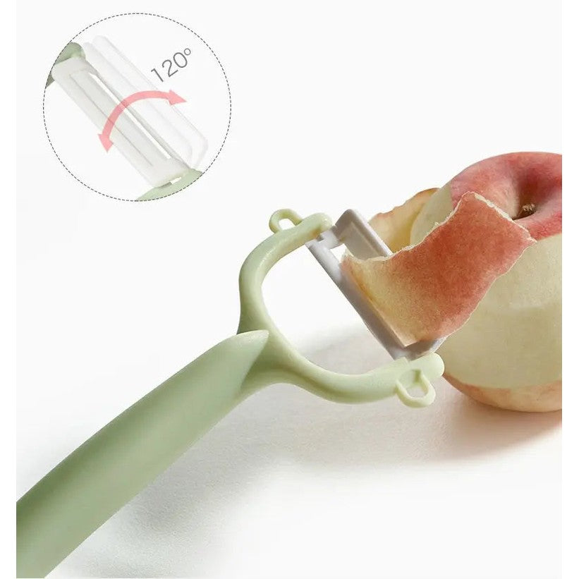 Bc Babycare Baby Food Ceramic Peeler in green with ergonomic handle peeling a peach using the ceramic blade.