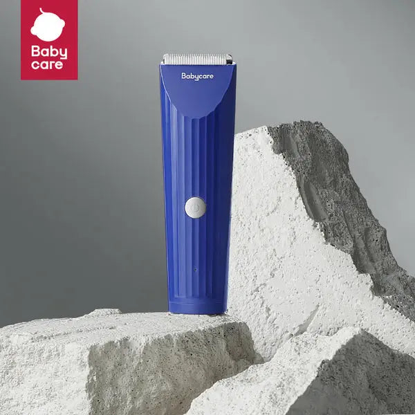 Bc Babycare Baby Hair Clipper in blue standing on white sand, showing silver blade for precise trimming.