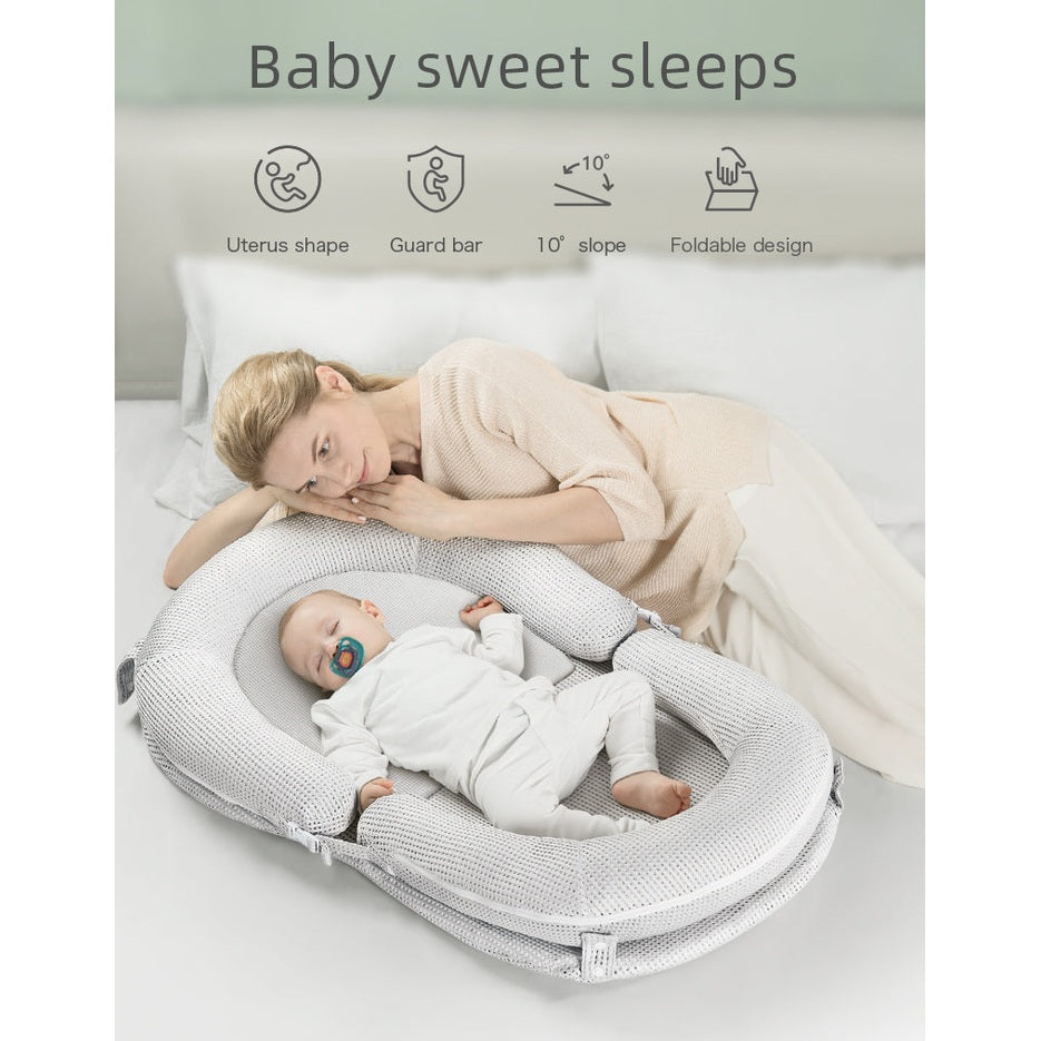 BC Babycare Baby Snuggle Nest in light gray knit; cozy newborn resting beside mother