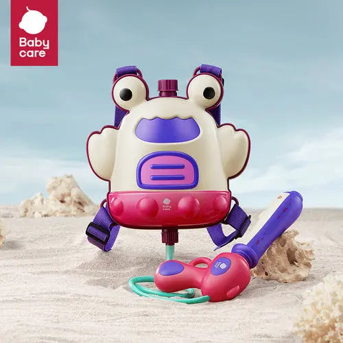 BC Babycare Backpack Water Blaster 2300 ml on the beach; frog backpack with purple straps sprays water through a pink nozzle.