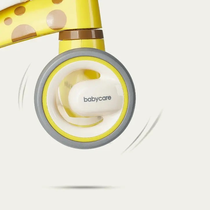 BC Babycare Balance Scooter, bright yellow with gray tire, shown in motion with a wheel lifting off the ground.