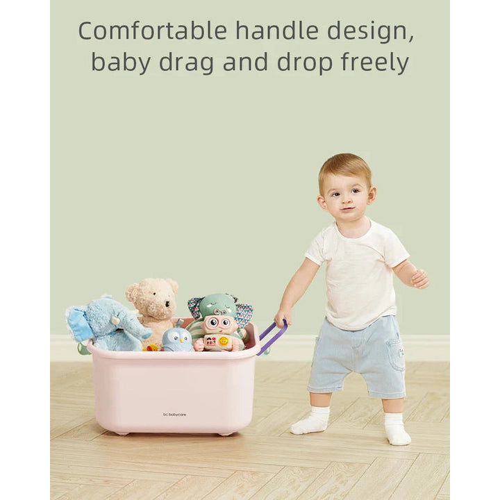 BC Babycare Building Blocks Storage Box in pink, tub full of toys and plushies beside a toddler