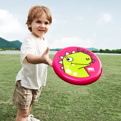 BC Babycare Children Soft Frisbee pink with yellow dinosaur graphic being tossed by a child outdoors