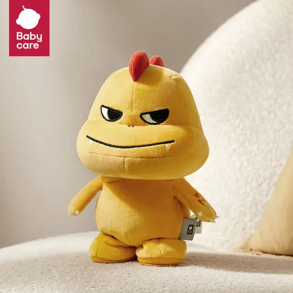 Bc Babycare Dynamic Toy plush yellow chick with red comb standing upright on a light sofa