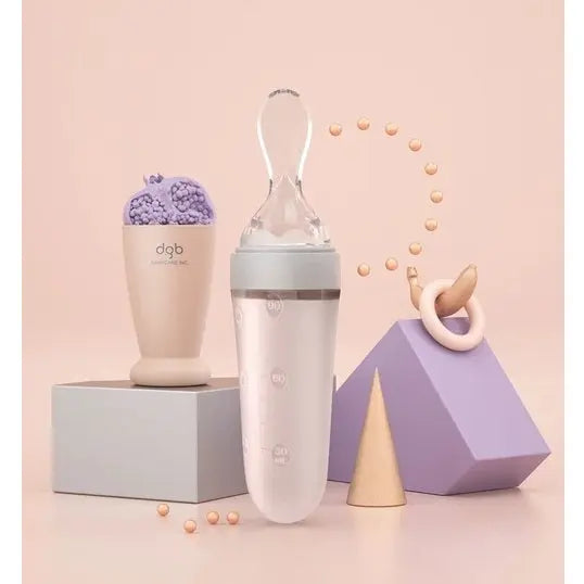 Bc Babycare Feeding Spoon Dispenser in pastel pink and white, shown upright with the built-in scoop visible.