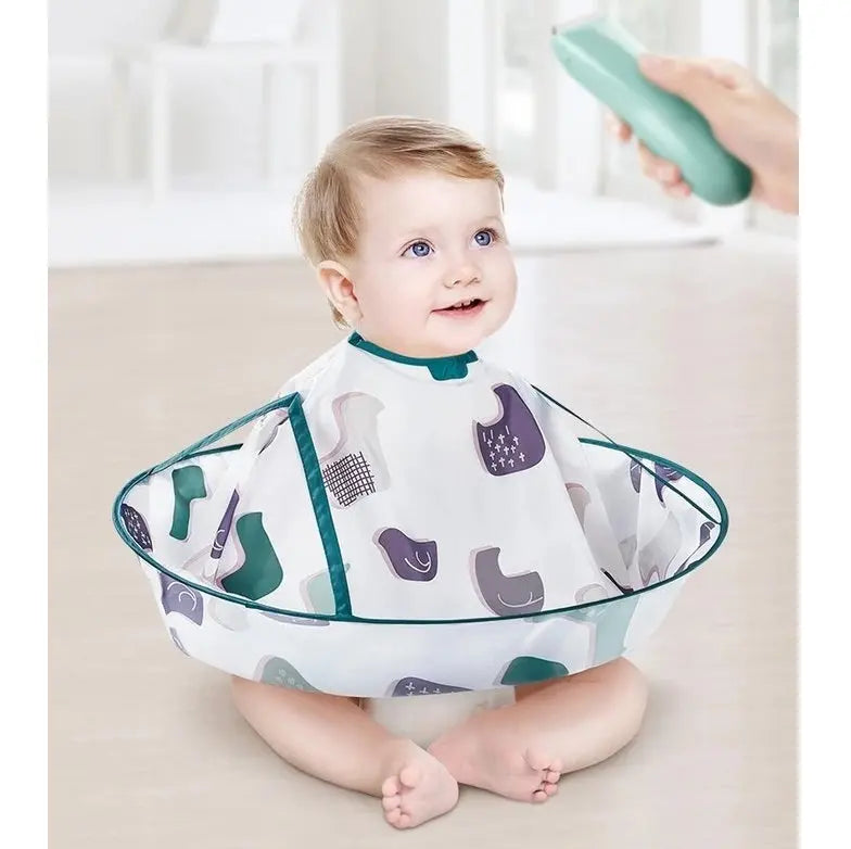 BC Babycare Haircut Cloak with teal trim worn by a smiling baby on the floor as a caregiver trims with a mint-green clipper.