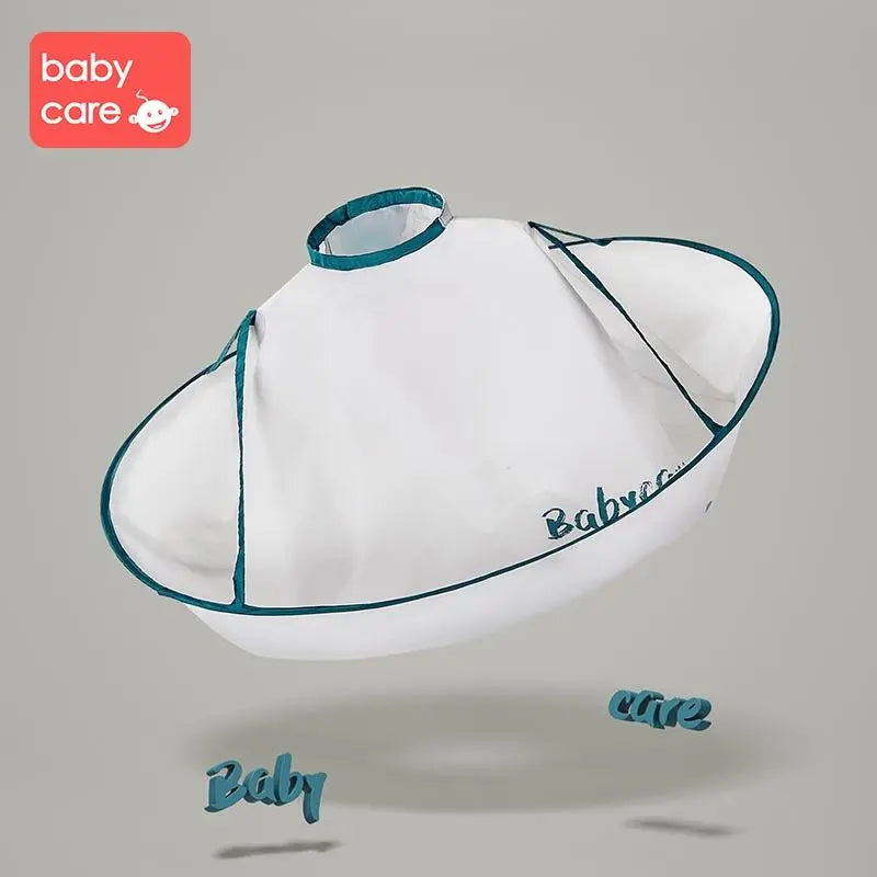 BC Babycare Haircut Cloak in white with teal trim and adjustable neck collar, shown floating as a toddler gets a trim.