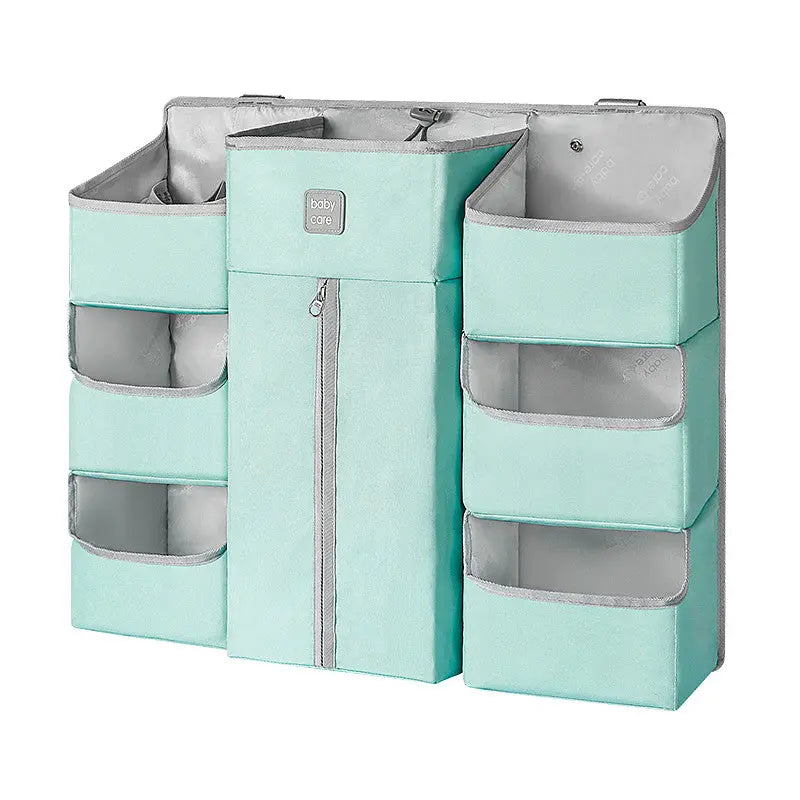 Bc Babycare Hanging Storage Bag in mint green with side pockets and a central zip panel, shown hanging in a closet.