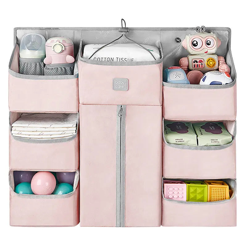 BC Babycare Hanging Storage Bag in pink with multiple pockets, where toys, diapers, and wipes are neatly stored.
