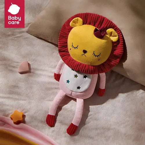 Bc Babycare Light & Musical Comforter Plush Lion Toy with pink body and star accents lying peacefully on a bed.