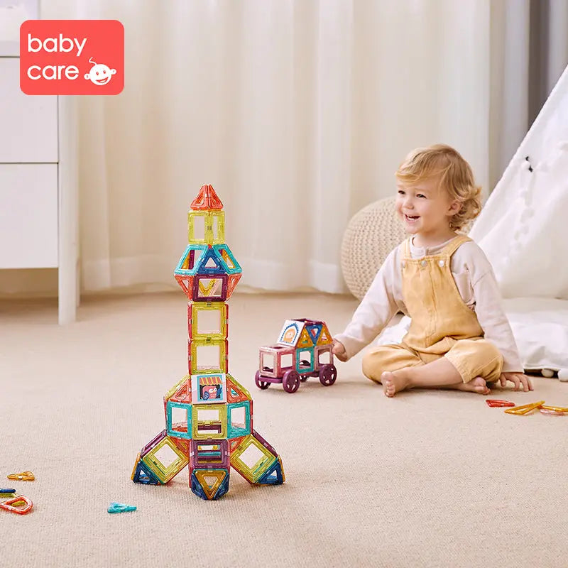 BC Babycare Magnetic Building Blocks Set; tall colorful magnetic tile tower beside a smiling toddler and a small wagon.