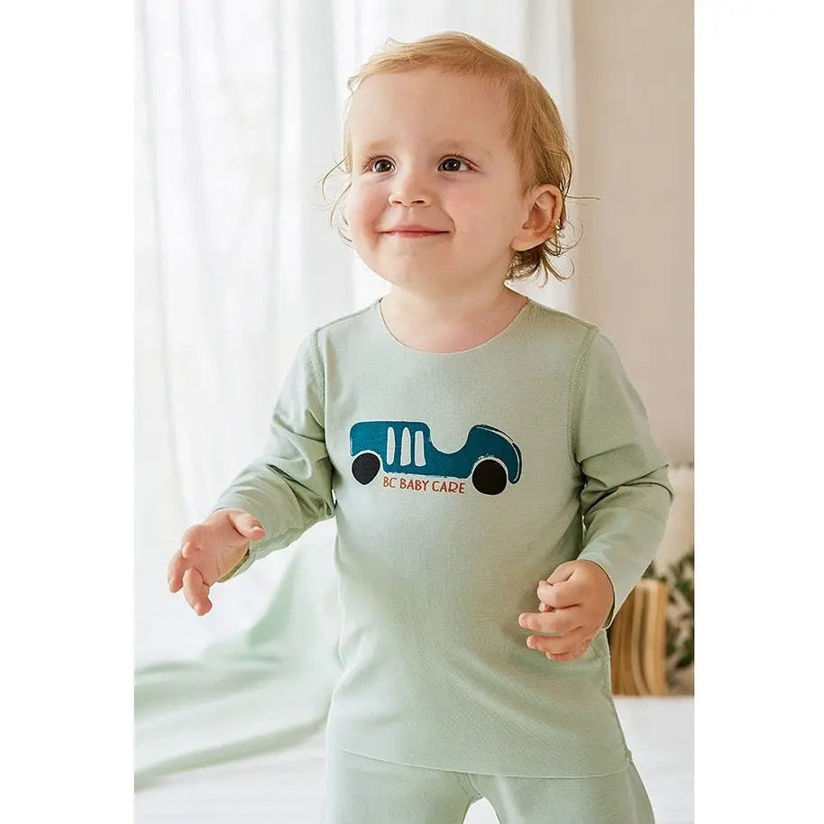 BC Babycare Modal Sleepsuit Green worn by a smiling toddler standing with arms out, blue truck print.