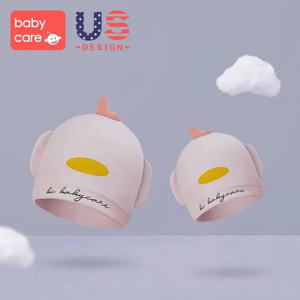 BC Babycare Newborn Hat Pink pair floats in a pastel scene, showcasing soft fabric and cute ear flaps.