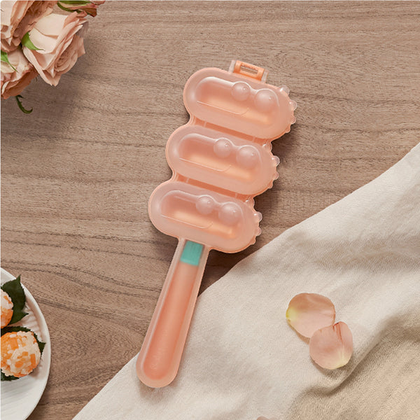 BC Babycare Rice Ball Maker with three pink mold compartments on a handle for baby feeding