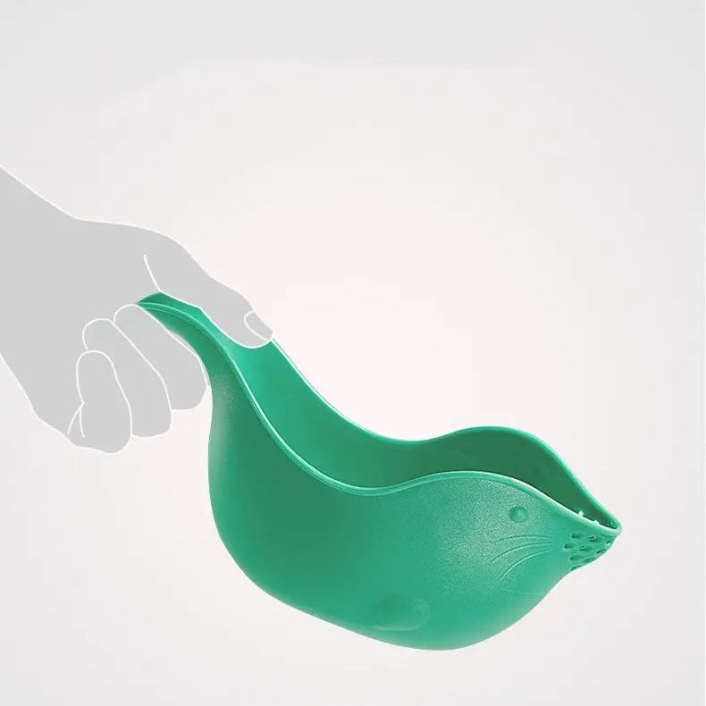 BC Babycare Shower Rinse Cup, green silicone with a seal-shaped body and easy-grip handle held by hand