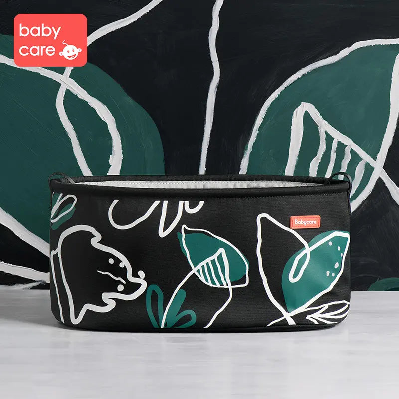BC Babycare Stroller Organizer in black with teal leaves, zipped top and red logo tag.