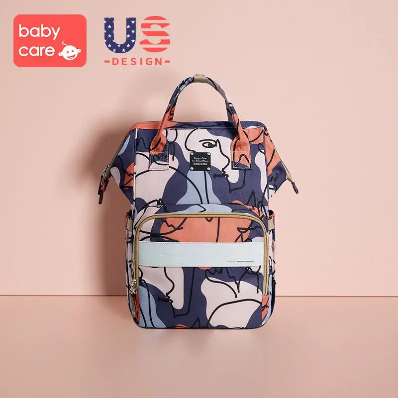 BC Babycare Waterproof Diaper Bag Plus, standing upright with top handles and front zip pocket, multicolor abstract pattern.