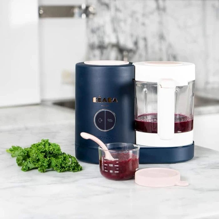Beaba Babycook Neo Midnight navy countertop appliance with white lid, glass pitcher and measuring cup with parsley garnish