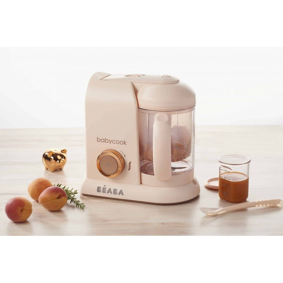 BEABA Babycook Solo baby food maker in rose gold with clear jar and measuring beaker