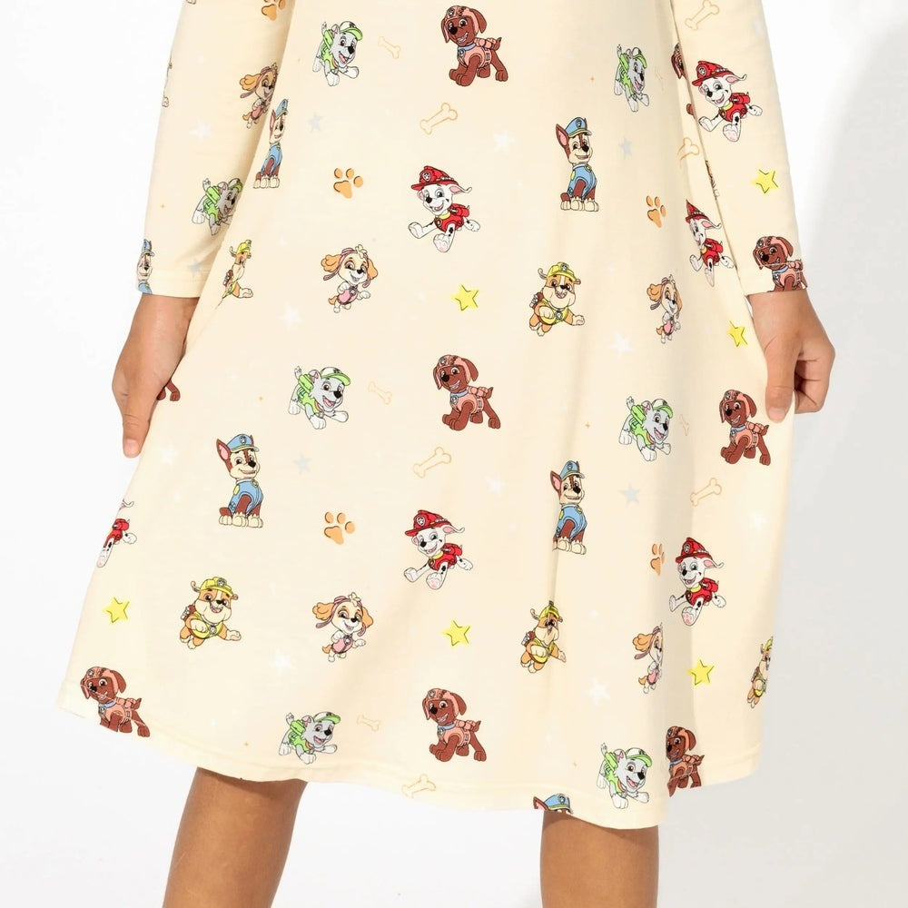 Bellabu Bear Bamboo Girls' Long Sleeve Dress Paw Patrol print on cream fabric, shown with hands at sides.