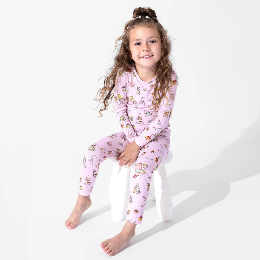 Bellabu Bear Bamboo Kids Pajamas Tea Party set in pink lavender, worn by a smiling girl in a long-sleeve top and pants.