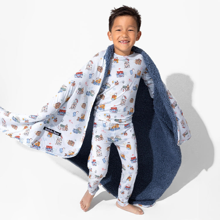 Bellabu Bear Bamboo Kids Pajamas Vintage Suitcases white with colorful print; boy twirls open navy fleece robe to reveal cozy lining.