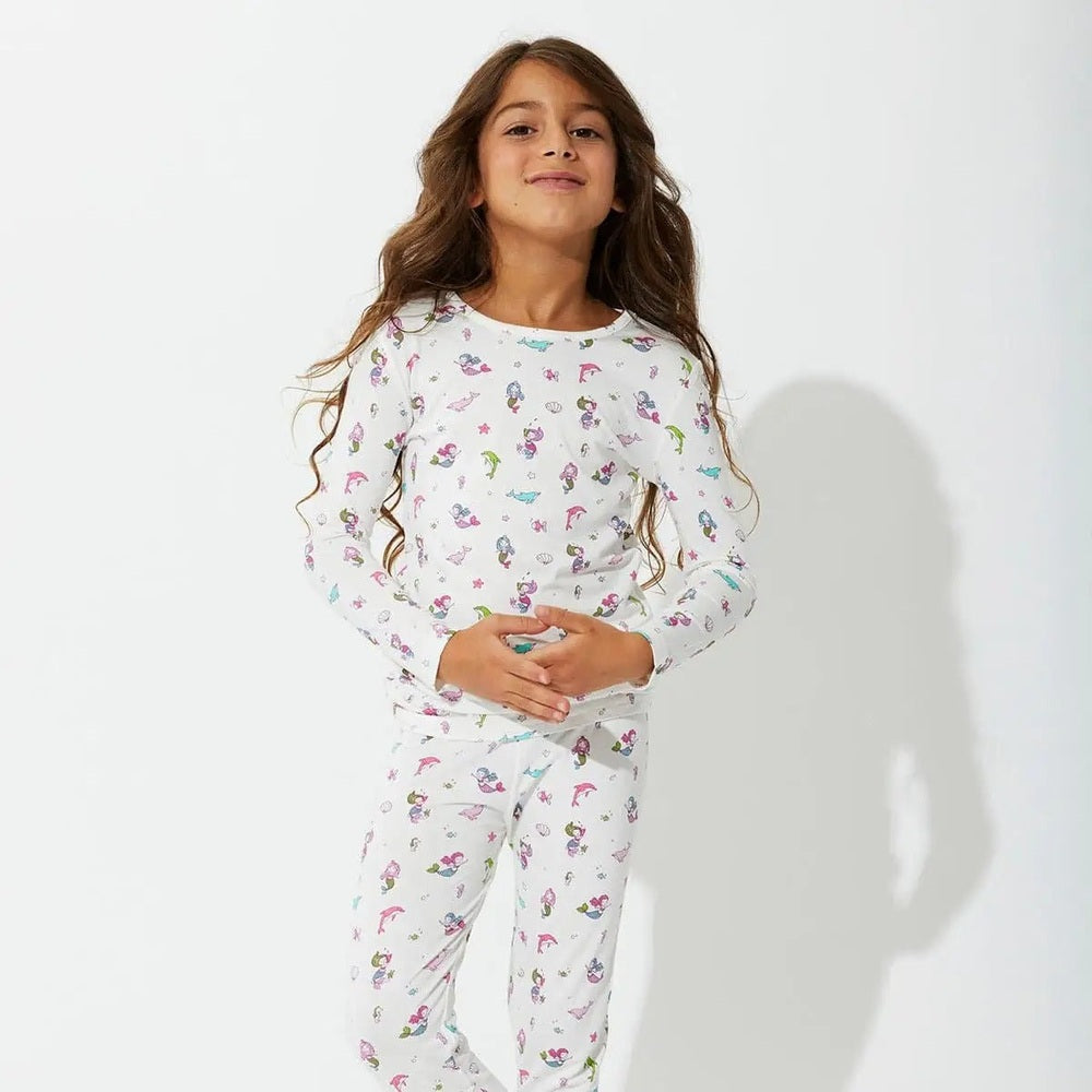 Bellabu Bear Bamboo Kids Pajamas Mermaid set worn by a smiling girl in white mermaid-print long-sleeve top and pants.