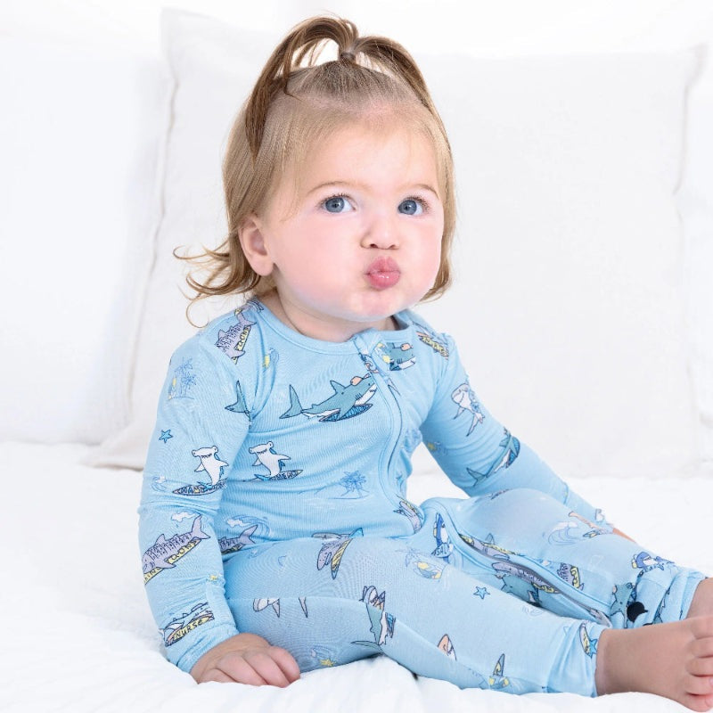 Bellabu Bear Bamboo Convertible Footie Shark School in light blue; baby sits on bed in zipper-front sleepwear.